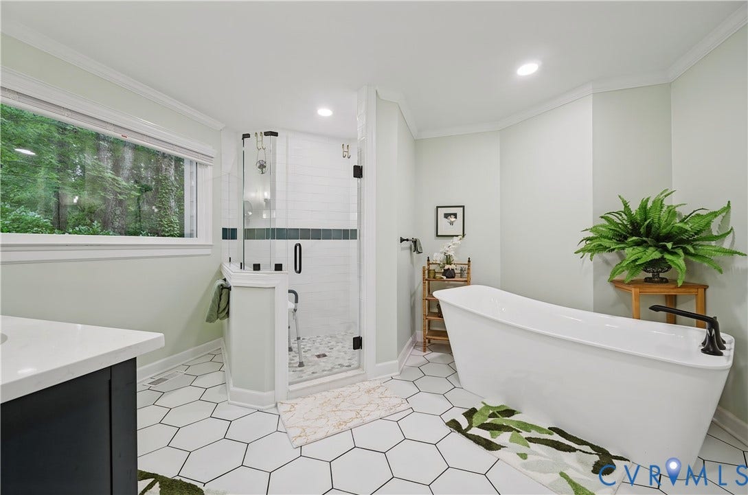 411 Hickory Drive, Manakin Sabot, VA 23103 Walk-in shower with clear glass enclosure and subway tile surround, freestanding soaking tub with floor-mounted faucet, hexagon tile flooring, single vanity with white countertop, and expansive window