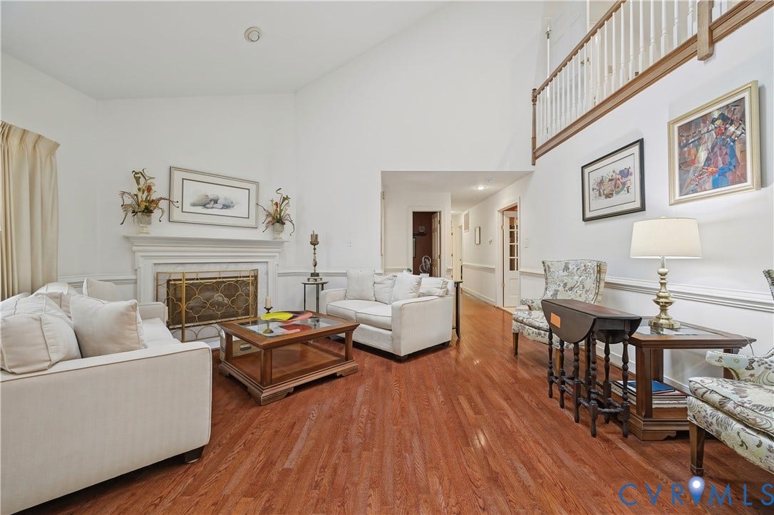 411 Hickory Drive, Manakin Sabot, VA 23103 Hardwood flooring, painted white walls, white fireplace with decorative screen, vaulted ceiling, and an open upper-level railing