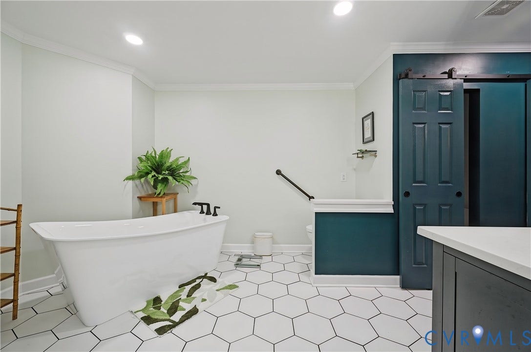 411 Hickory Drive, Manakin Sabot, VA 23103 Freestanding bathtub with matte black fixtures, white hexagonal tile flooring, and a dark-paneled barn door