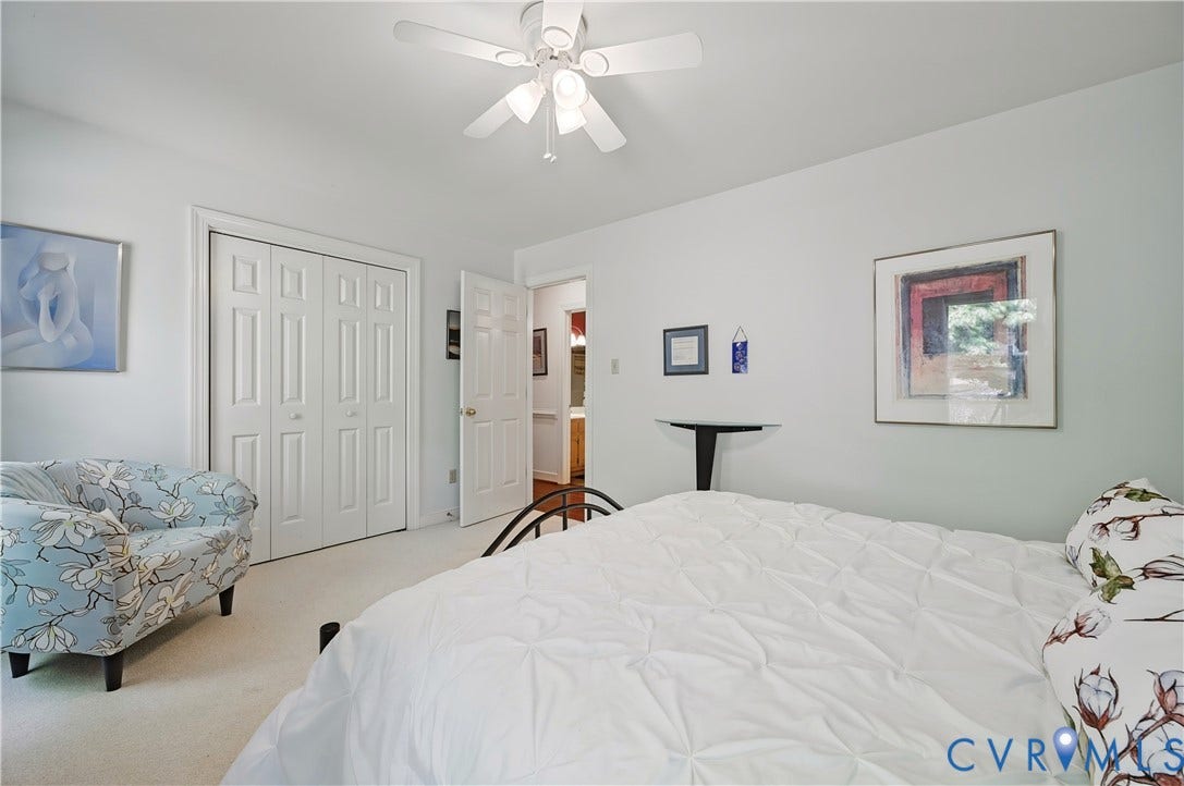 411 Hickory Drive, Manakin Sabot, VA 23103 Spacious bedroom featuring neutral wall finishes, carpeted flooring, a ceiling fan with integrated lighting, and dual closets with louvered doors