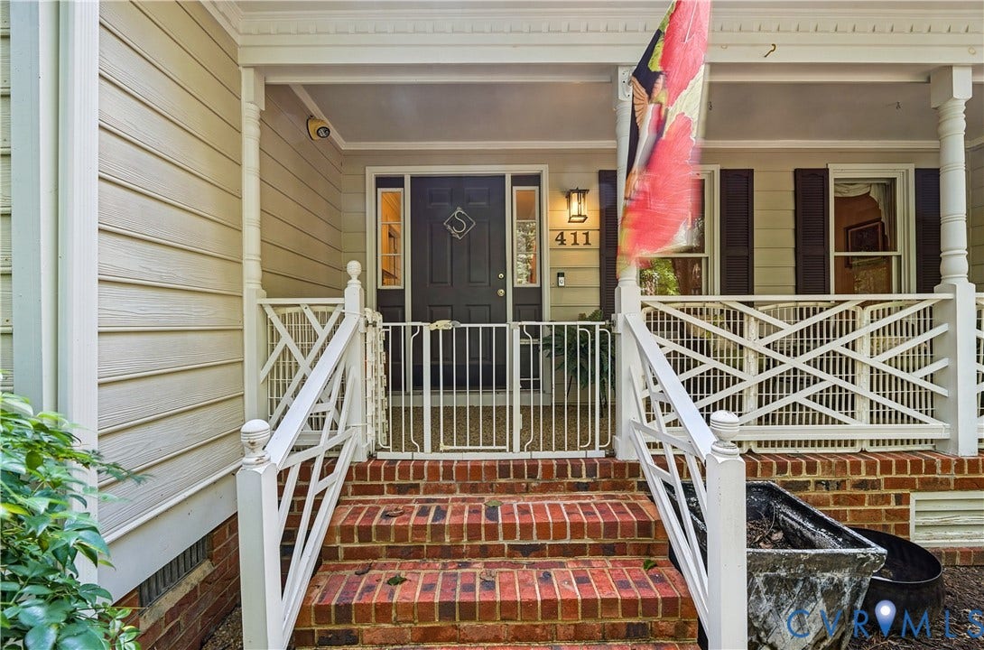 411 Hickory Drive, Manakin Sabot, VA 23103 Brick steps leading to a covered porch with white railing, a dark front door, and exterior wall lanterns