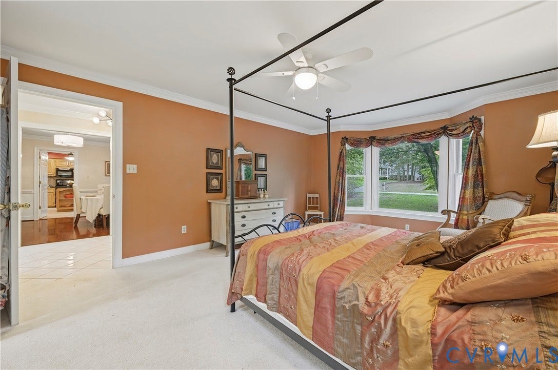 411 Hickory Drive, Manakin Sabot, VA 23103 Bay window, ceiling fan, white crown molding, light-colored carpeting, and a doorway opening to a room with wood-finish flooring