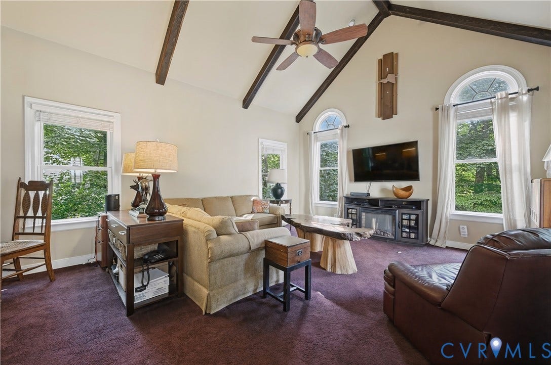 411 Hickory Drive, Manakin Sabot, VA 23103 Vaulted ceiling with exposed wood beams, ceiling fan, arched windows, and a built-in media console with an electric fireplace
