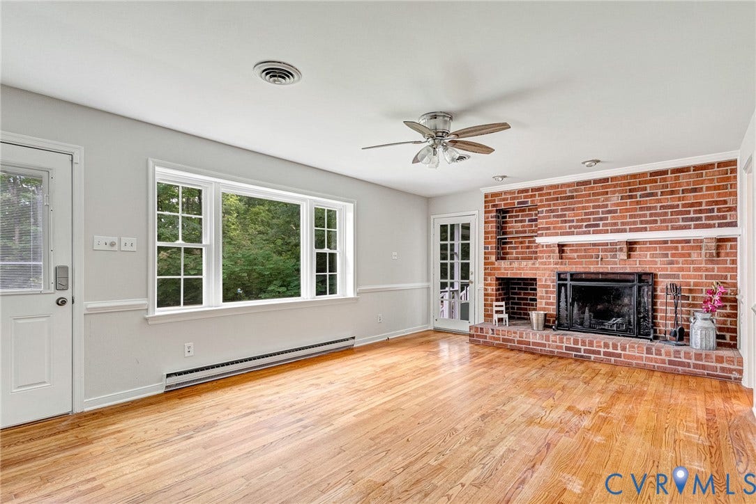 10478 Gould Hill Road, Studley, Hanover, VA 23069 Brick fireplace with a stone hearth, wood-finish flooring, ceiling fan, and large windows