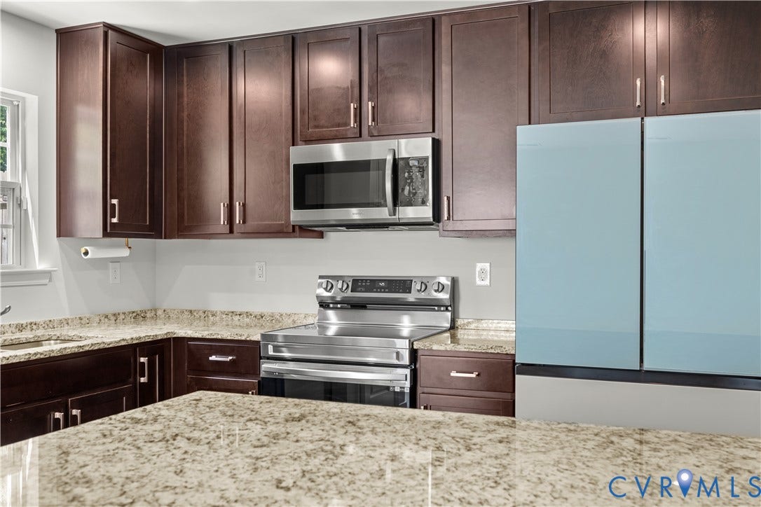 3372 Dewsberry Lane, Henrico, VA 23231 Dark wood-finish cabinetry with silver hardware, speckled stone countertops, stainless steel microwave, and stainless steel range