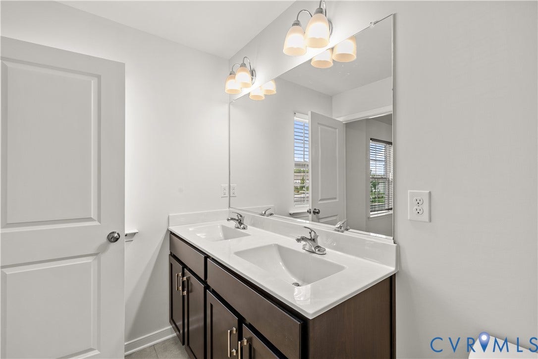3372 Dewsberry Lane, Henrico, VA 23231 Dual sink vanity with dark wood-finish cabinetry, chrome hardware, and a light-toned countertop