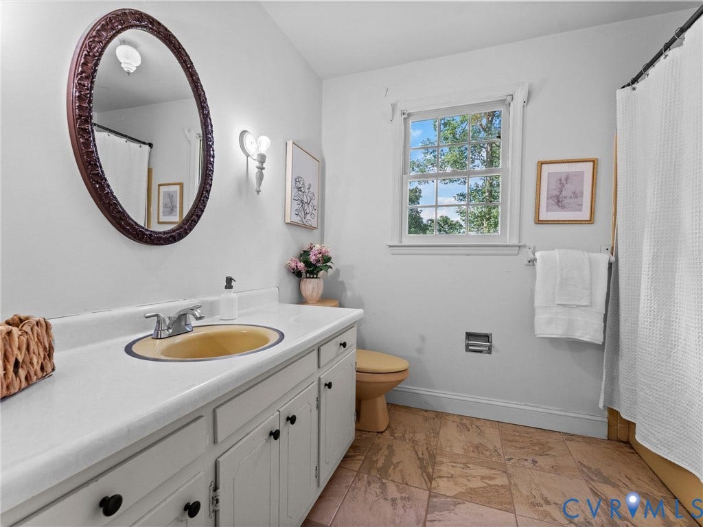 3610 Castlebury Drive, Chester, VA 23831 Vanity with a built-in sink, wall-mounted sconce lighting, window with exterior views, and tile flooring
