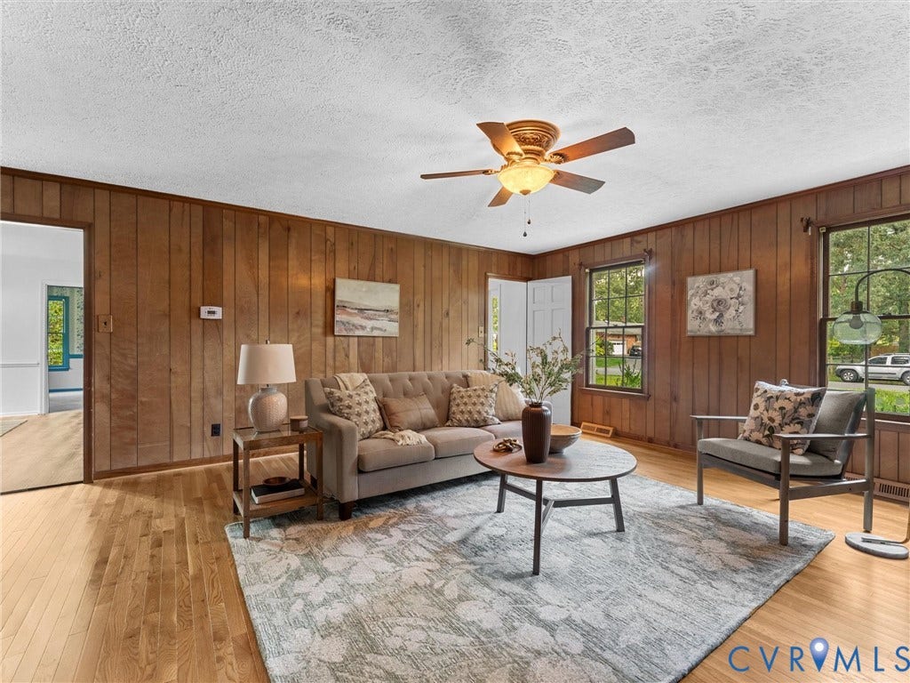 3610 Castlebury Drive, Chester, VA 23831 Wood paneling, hardwood flooring, ceiling fan with integrated lighting, double-hung windows, and a paneled interior door