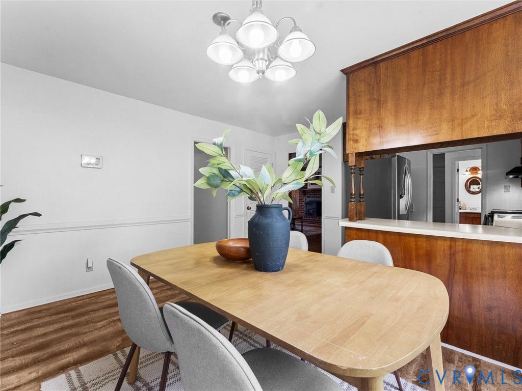 3610 Castlebury Drive, Chester, VA 23831 Wood-finish flooring, white walls, and a wood-paneled breakfast bar with a white countertop