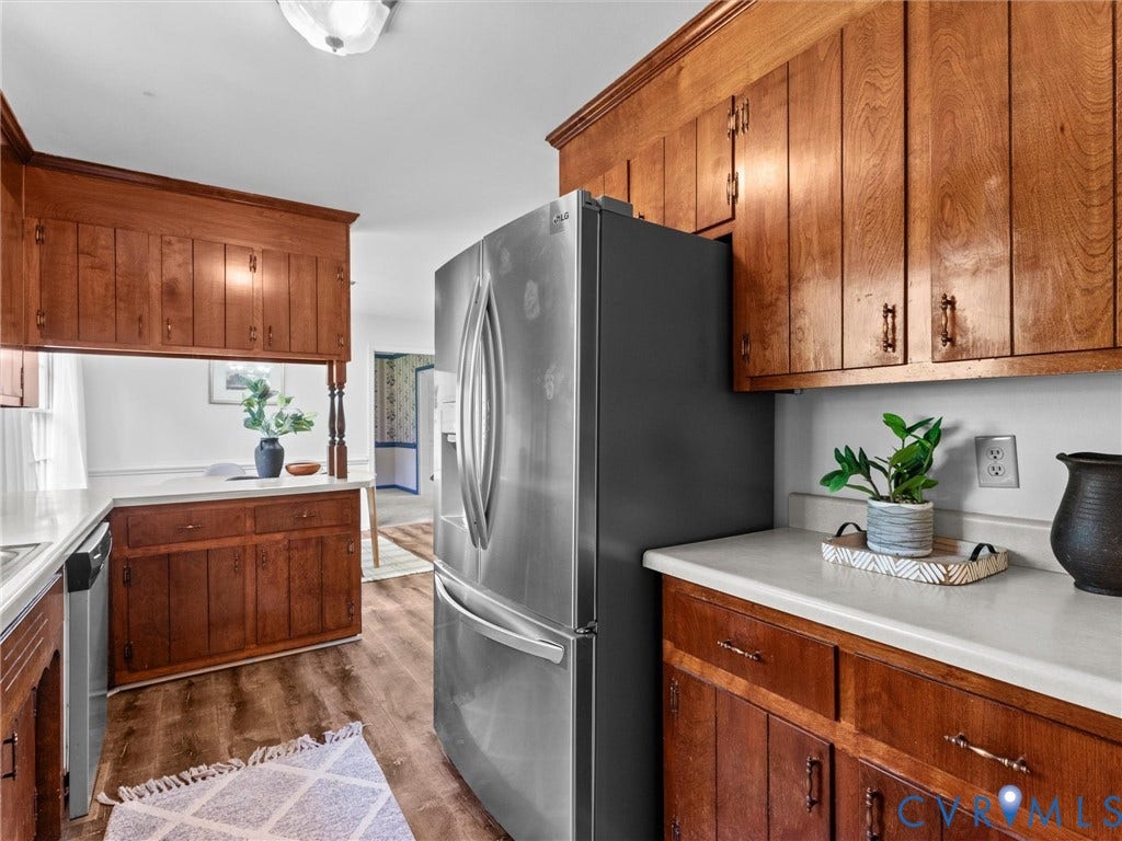 3610 Castlebury Drive, Chester, VA 23831 Wood-finish flooring, white countertops, built-in cabinetry, and a stainless steel refrigerator