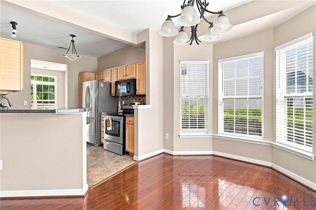 3818 Dominion Townes Circle, Dominion Townes, Richmond, VA 23223 Bay window with multiple double-hung windows, wood-finish flooring, and a decorative chandelier