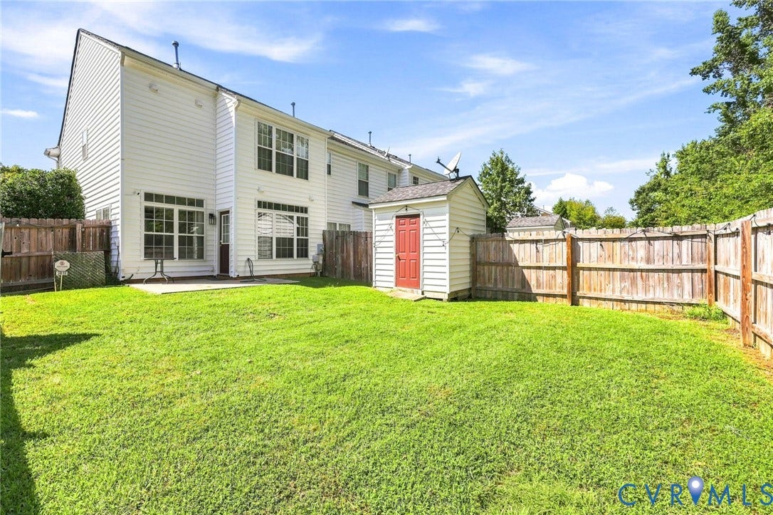 3818 Dominion Townes Circle, Dominion Townes, Richmond, VA 23223 Expansive grassy yard with wood fencing, a storage shed, and a concrete patio