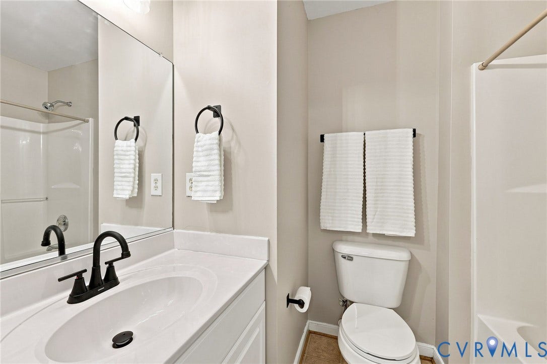 3818 Dominion Townes Circle, Dominion Townes, Richmond, VA 23223 Bathroom featuring tub/shower combo, a built-in vanity with an integrated sink, black-finish faucet, and a large wall-mounted mirror