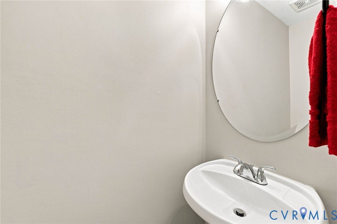 3818 Dominion Townes Circle, Dominion Townes, Richmond, VA 23223 Pedestal sink with chrome-finish faucet and an oval wall mirror