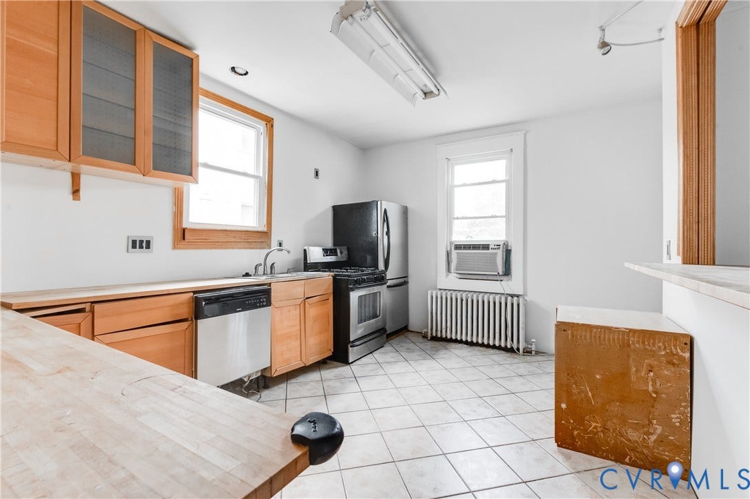 Kitchen featuring tiled flooring, wood-finish cabinetry, a stainless steel dishwasher, a stainless steel range, and a stainless steel refrigerator