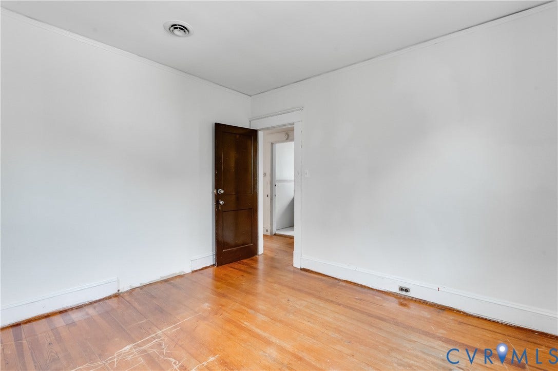Warm wood-finish flooring with white baseboards