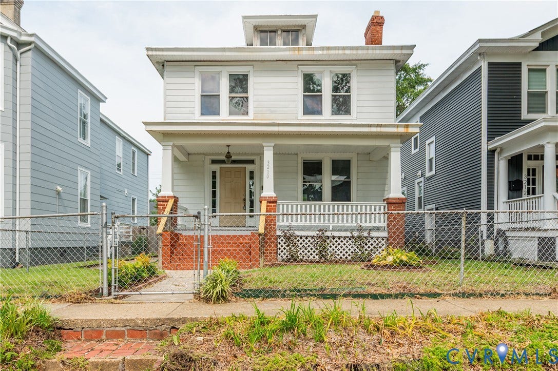 Two-story home with a prominent front porch, white siding, and a red brick foundation