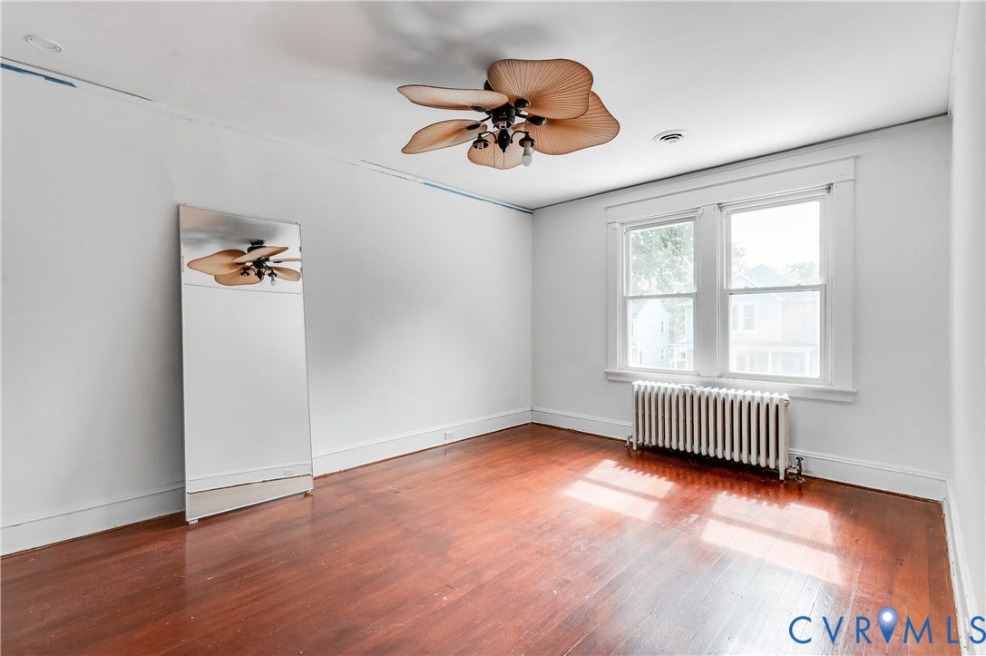 Wood-finish flooring, white walls, and a ceiling fan with integrated lighting