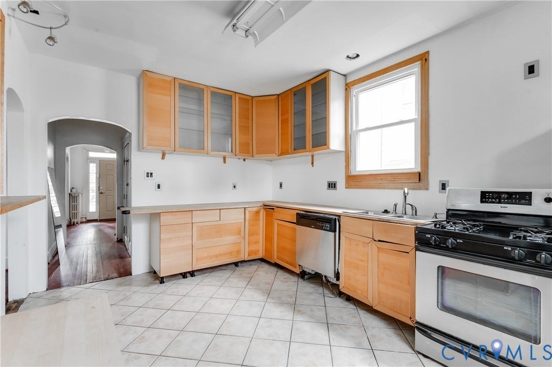Kitchen featuring light wood-finish cabinetry, stainless steel dishwasher, stainless steel range, and tile flooring