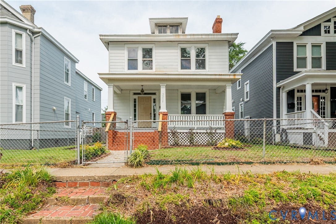 Two-story residence with white siding and a covered front porch featuring white columns