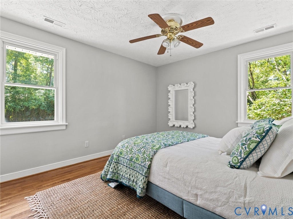 Primary suite with private bathroom, hardwoods, ceiling fan, and closet