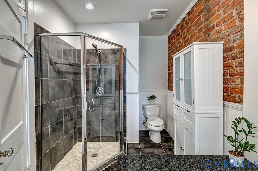 Glass-enclosed tiled shower with