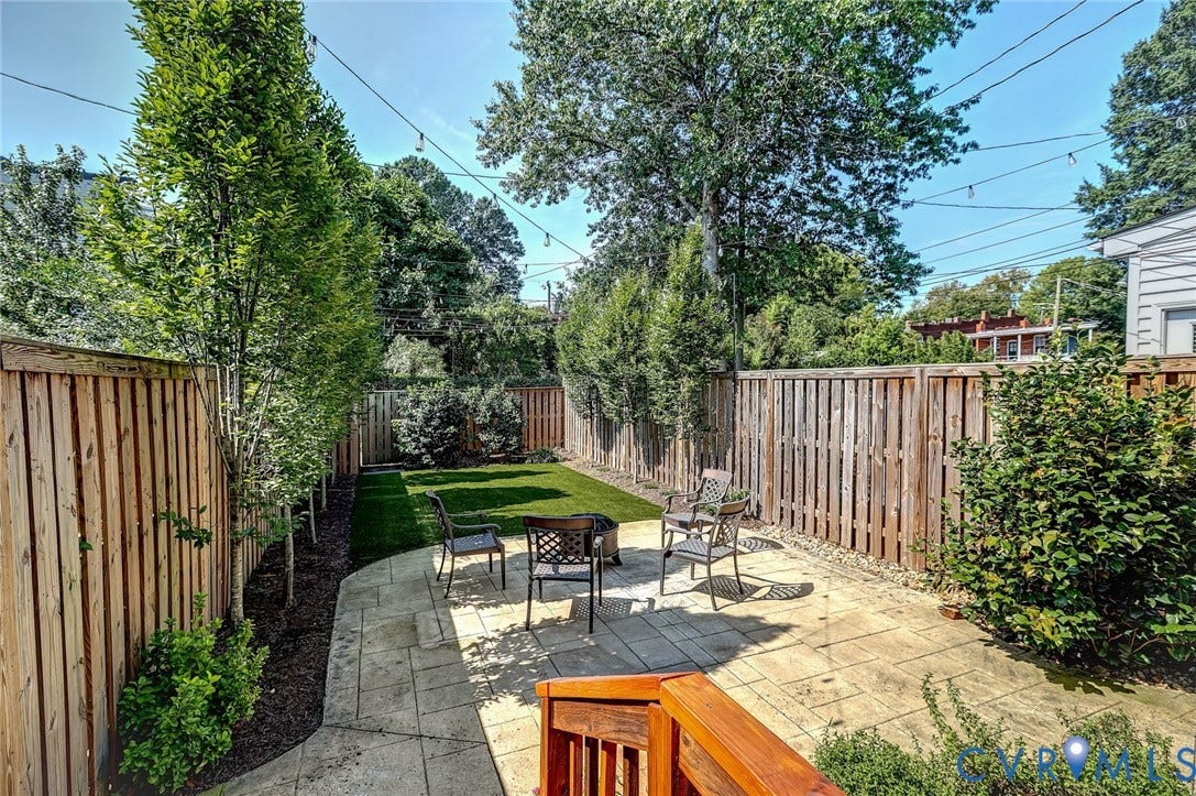 Private backyard featuring privacy fence, a paved patio area with seating space, and shade tree alle