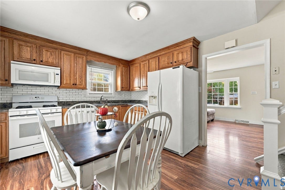 Kitchen featuring wood-finish flooring, wood cabinetry, subway tile backsplash, and a white appliance package