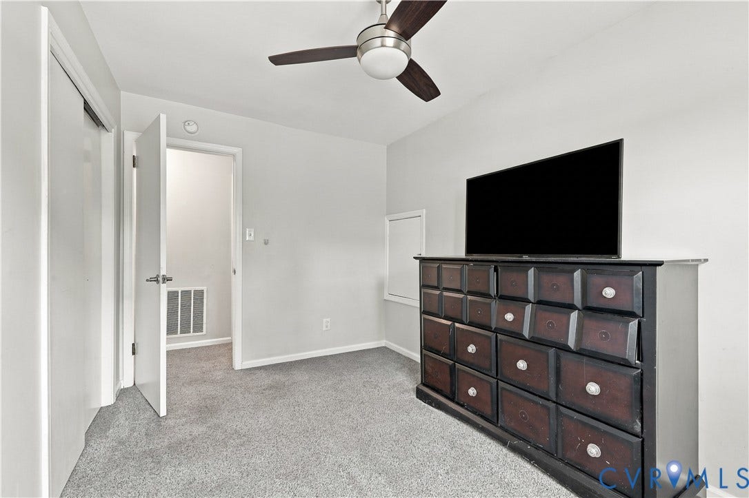 Plush carpeting, neutral wall color, and a ceiling fan with integrated lighting