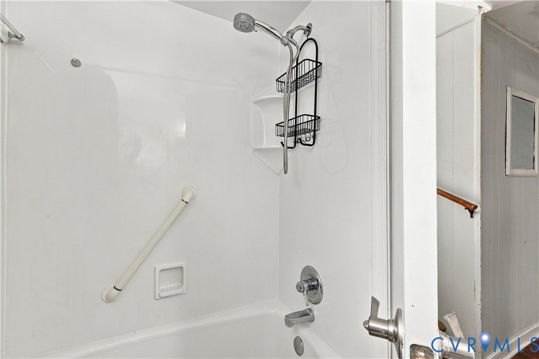 Tub and shower combination with a showerhead and grab bar