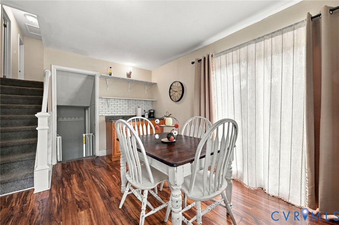 Wood-finish flooring, built-in shelving, white subway tile backsplash, and a sliding glass door