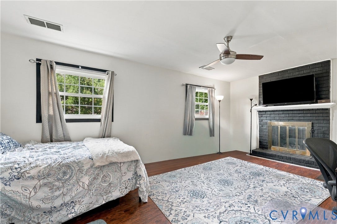 Wood-finish flooring, white walls, and a ceiling fan with integrated lighting