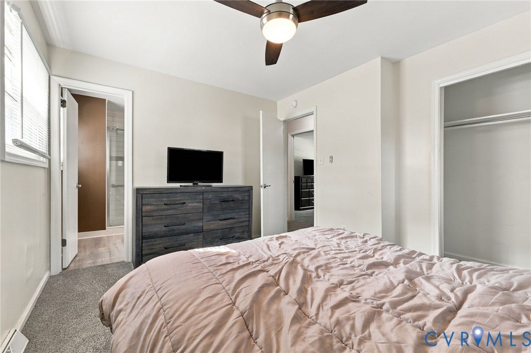 Carpeted room featuring a ceiling fan with integrated lighting, a window with blinds, and an open closet with hanging rods