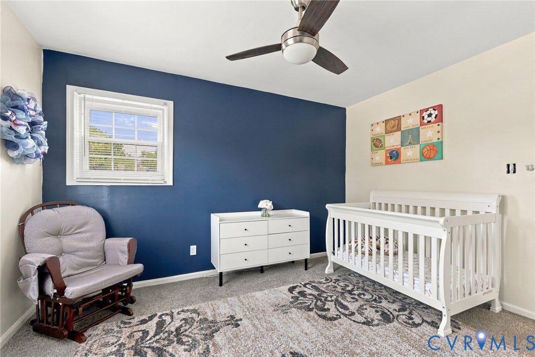 Recessed window with white blinds, ceiling fan with integrated lighting, and carpeted flooring