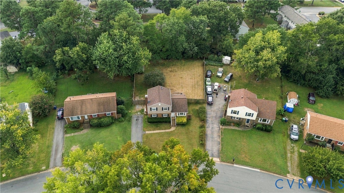 Residential property featuring a shingle roof and surrounding green spaces