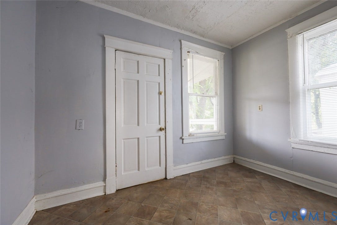 209 W 34th Street, Richmond, VA 23225 Neutral wall color, panel door, and two windows with blinds