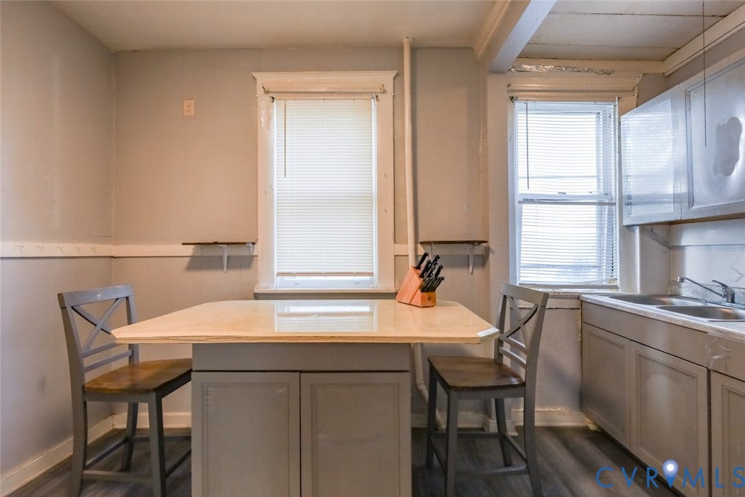 209 W 34th Street, Richmond, VA 23225 White window blinds, light wood-finish flooring, two windows, built-in lower cabinetry, and a double basin sink