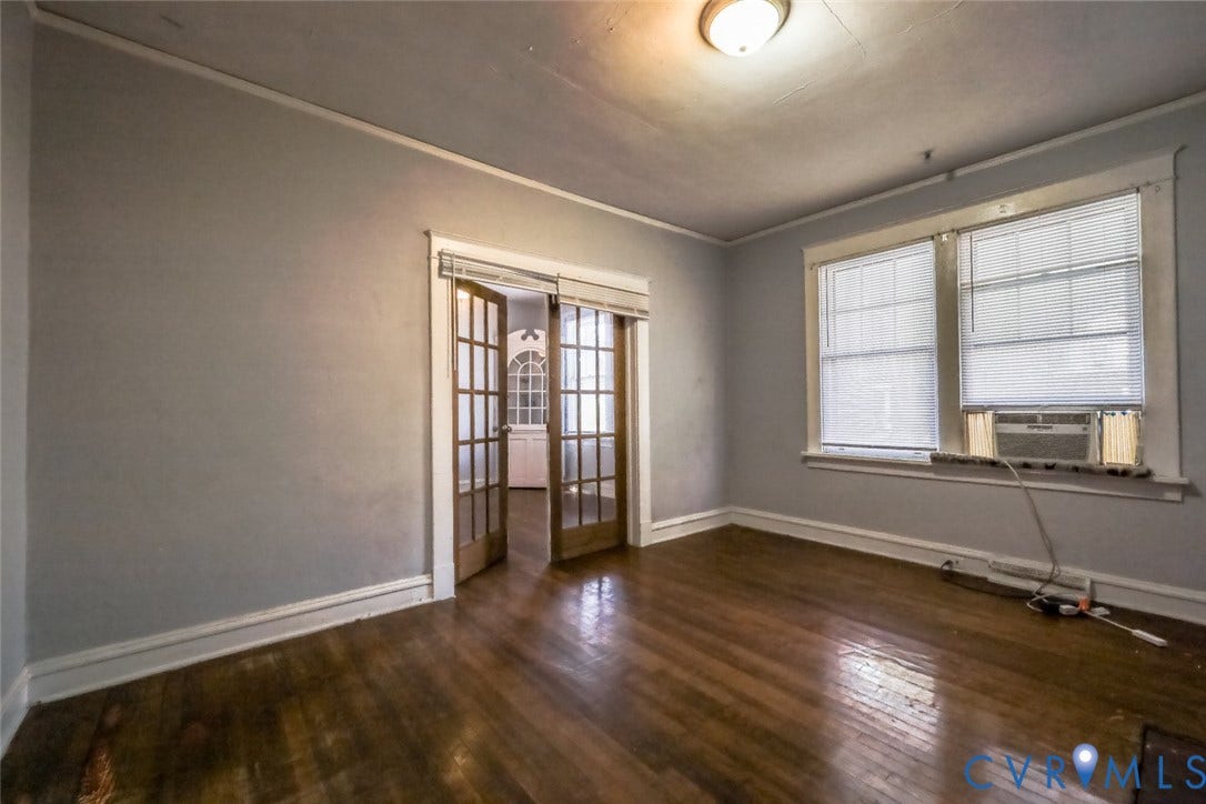 209 W 34th Street, Richmond, VA 23225 Hardwood flooring, crown molding, two large windows, an overhead light fixture, and double glass-paneled doors