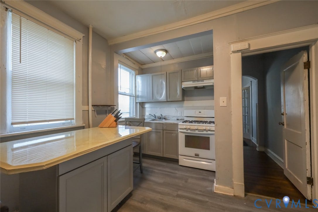 209 W 34th Street, Richmond, VA 23225 Kitchen featuring sleek cabinetry, light-toned countertops, a gas range, and wood-finish flooring