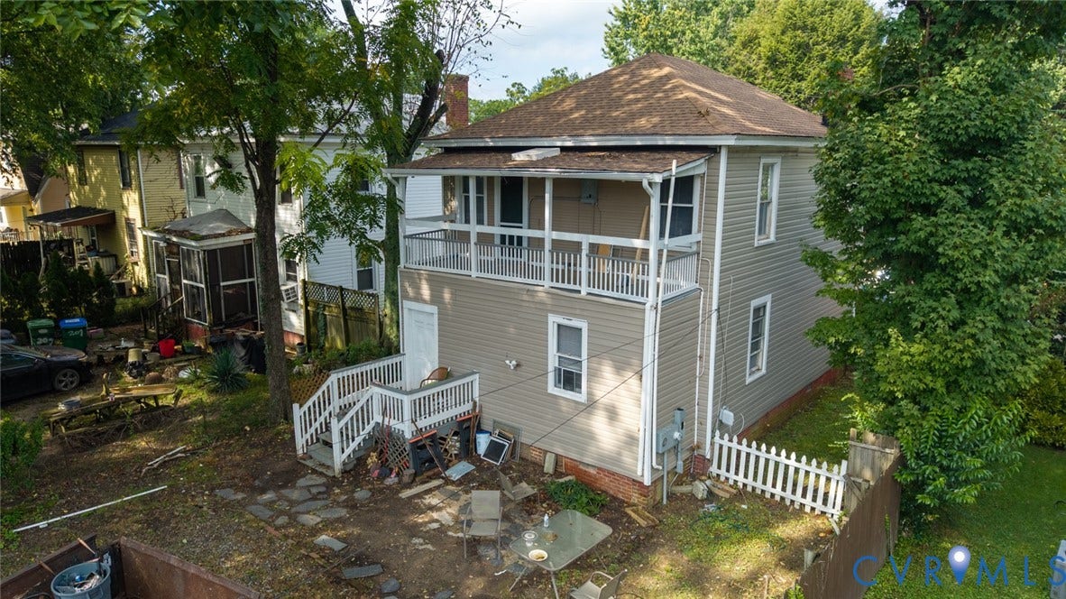 209 W 34th Street, Richmond, VA 23225 Two-story property with light-colored siding, a second-story balcony with white railings, and a lower-level exterior staircase