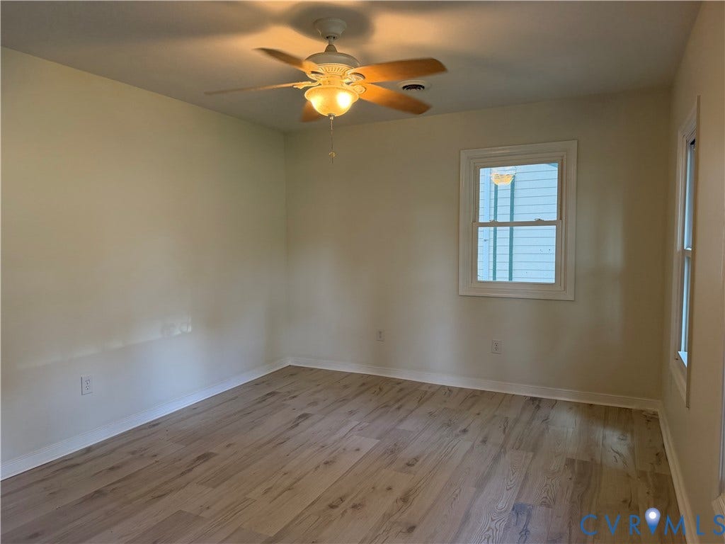 4706 Glen Tara Drive, Midlothian, VA 23112 Light-toned wood-finish flooring, two windows with white trim, and a ceiling fan with integrated lighting