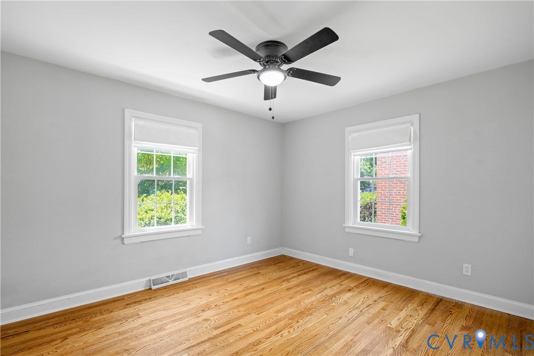 6710 Hanover Avenue, Westhampton Heights, Richmond, VA 23226 Hardwood flooring throughout, two windows with white trim, matte black ceiling fan with integrated lighting, and light-toned wall paint