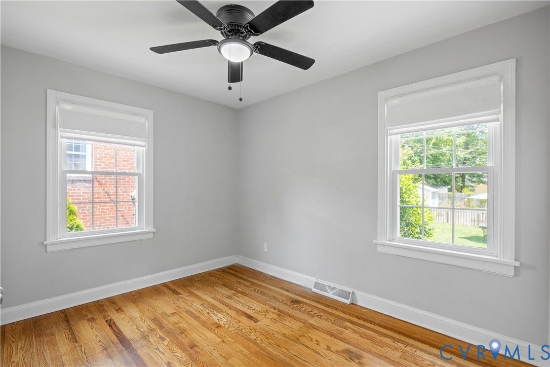 6710 Hanover Avenue, Westhampton Heights, Richmond, VA 23226 Hardwood flooring, two windows with white trim, ceiling fan, and light gray wall color