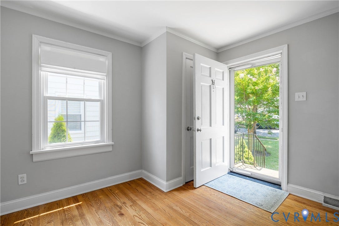 6710 Hanover Avenue, Westhampton Heights, Richmond, VA 23226 Hardwood flooring, painted walls, white trim, paneled door, and a single-hung window with a roller shade