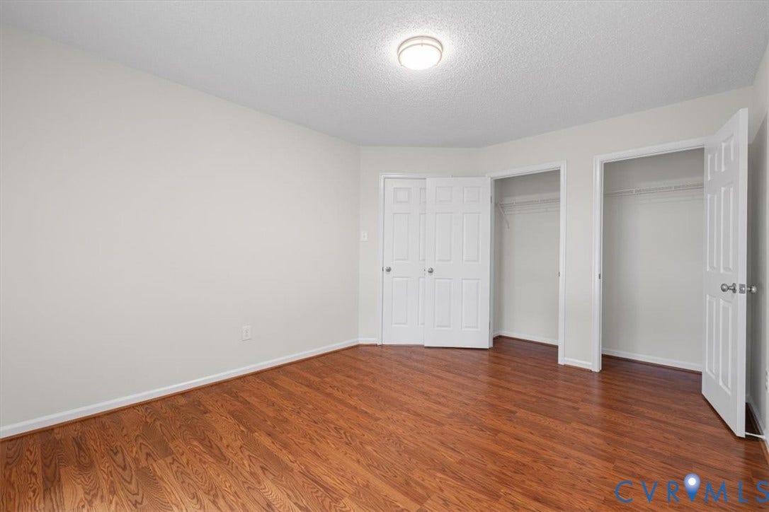 Warm wood-finish flooring, white walls, and a recessed ceiling light