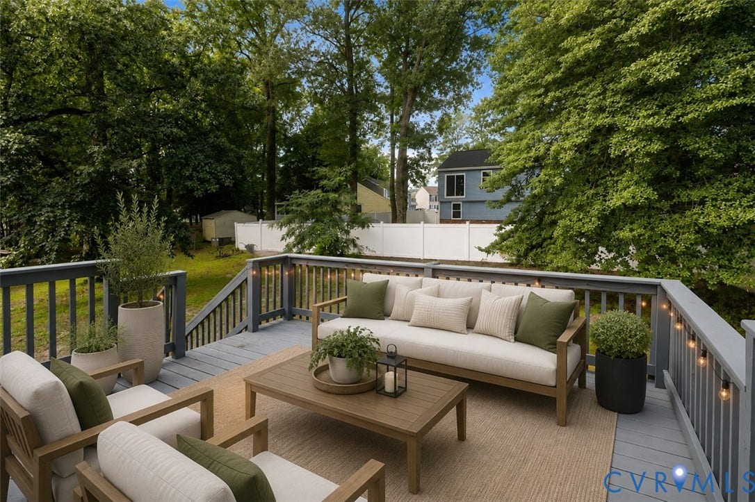 Expansive outdoor deck featuring wood flooring, a wood railing, and integrated string lighting