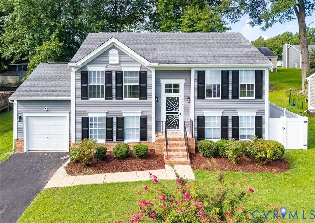Two-story residence featuring light gray siding with white trim, a dark gray Dimensional shingle roof, and a single-car garage with a New white door