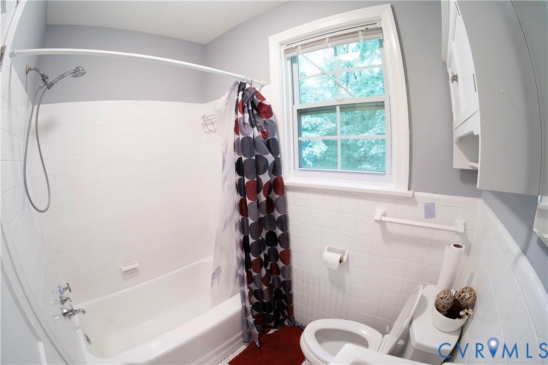6706 Jahnke Road, Richmond, VA 23225 White tiled shower and bathtub combination with a chrome shower fixture