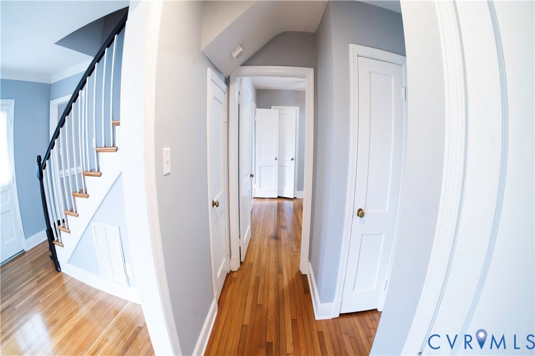 6706 Jahnke Road, Richmond, VA 23225 Hardwood flooring, painted walls, white trim, white doors, and a staircase with white risers and balusters