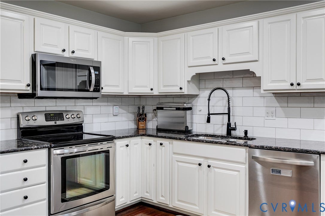 2844 Broadford Lane, Henrico, VA 23233 White shaker-style cabinetry with dark hardware, stainless steel appliances, dark countertops, white subway tile backsplash, and a black gooseneck faucet